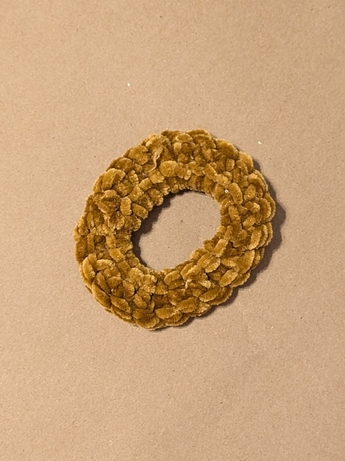 Gold scrunchie on a beige background