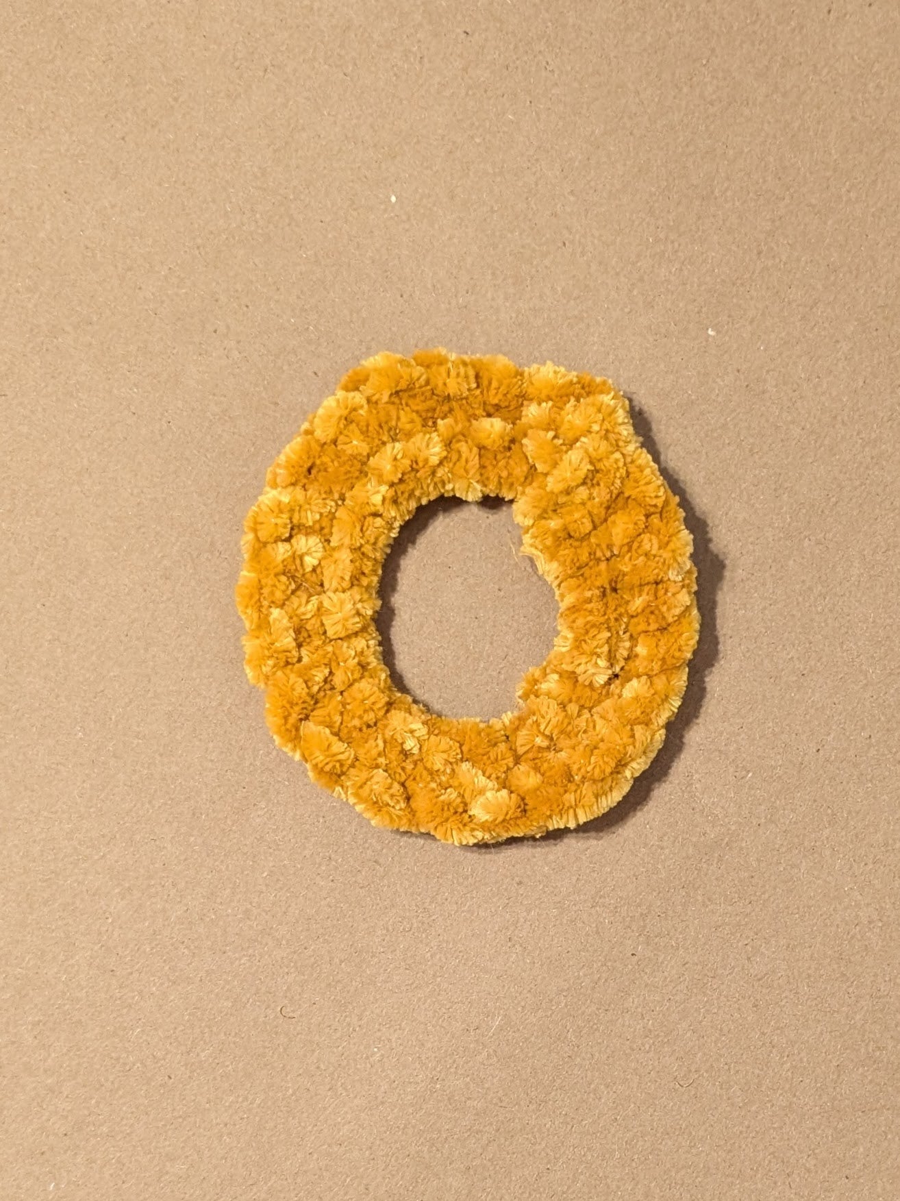 Yellow scrunchie on a beige background