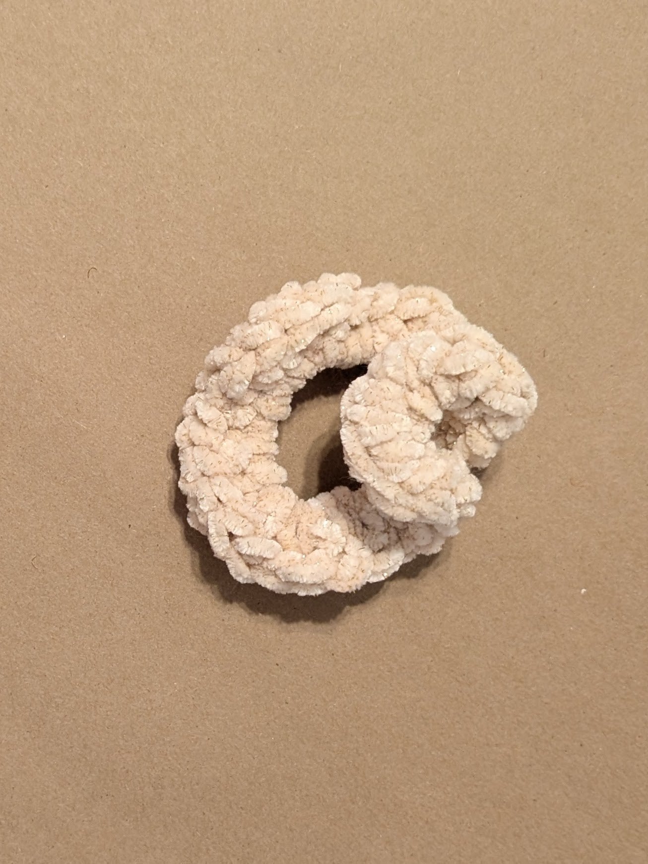 Off white scrunchie on a beige background