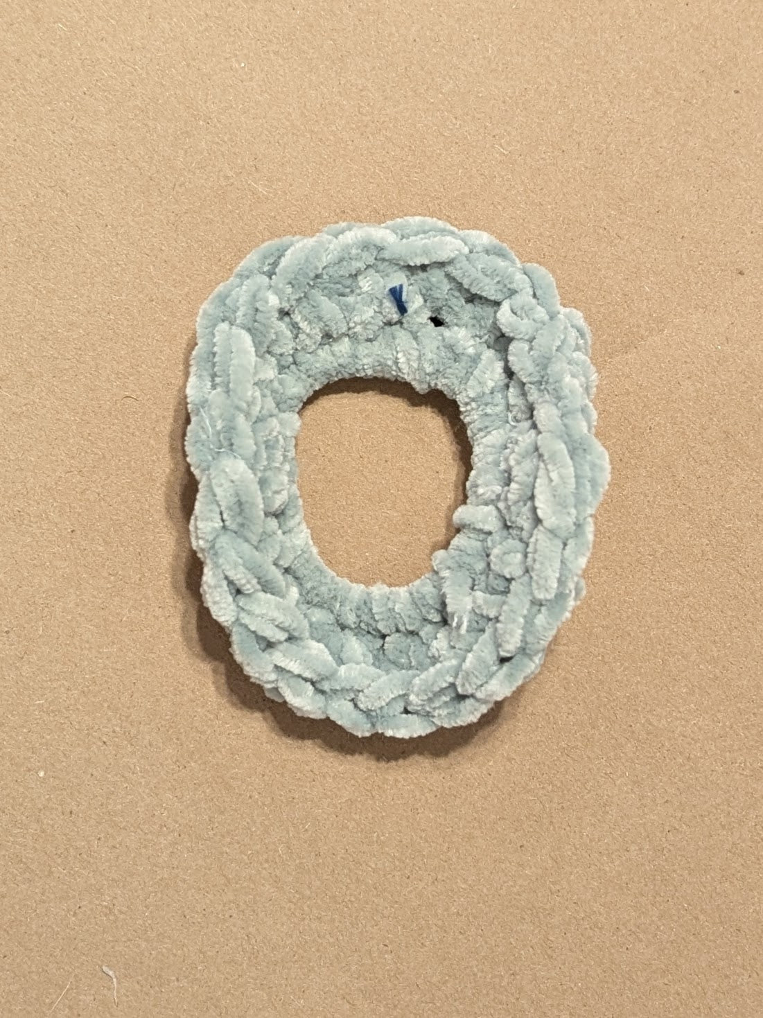 Light blue scrunchie on a beige background