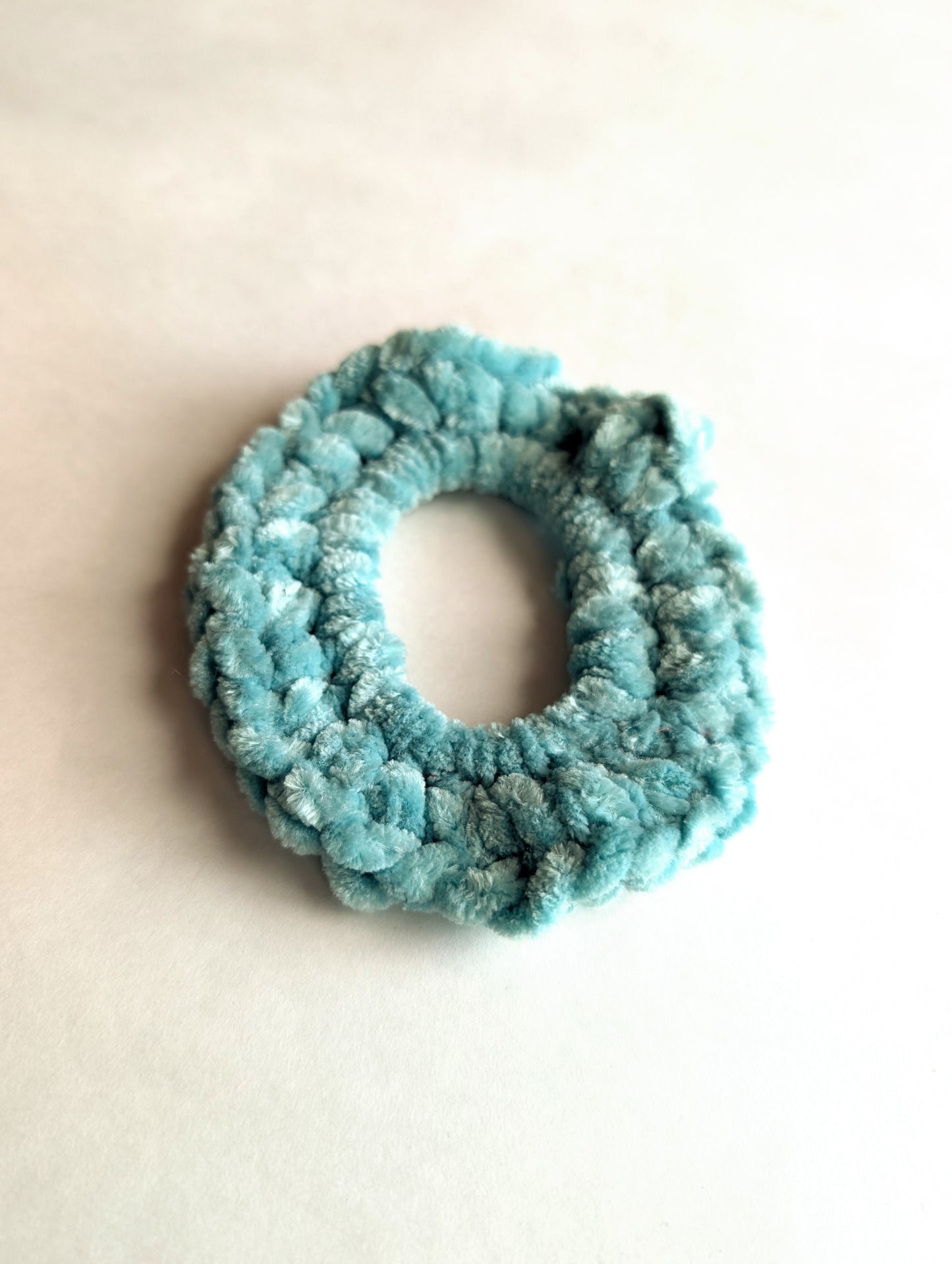 Mint scrunchie on a light beige background