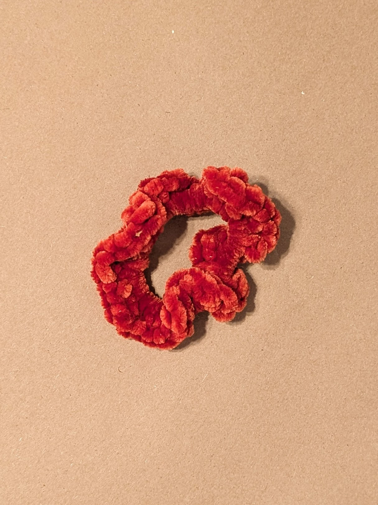 Red orange scrunchie on a beige background