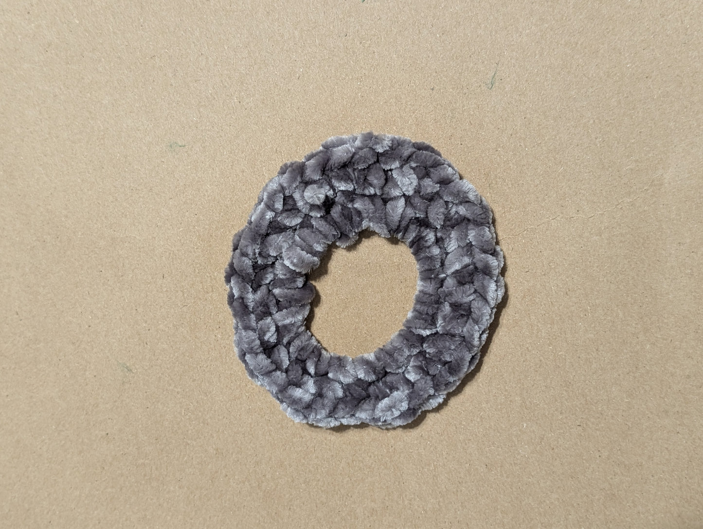 Gray textured scrunchie on a beige background