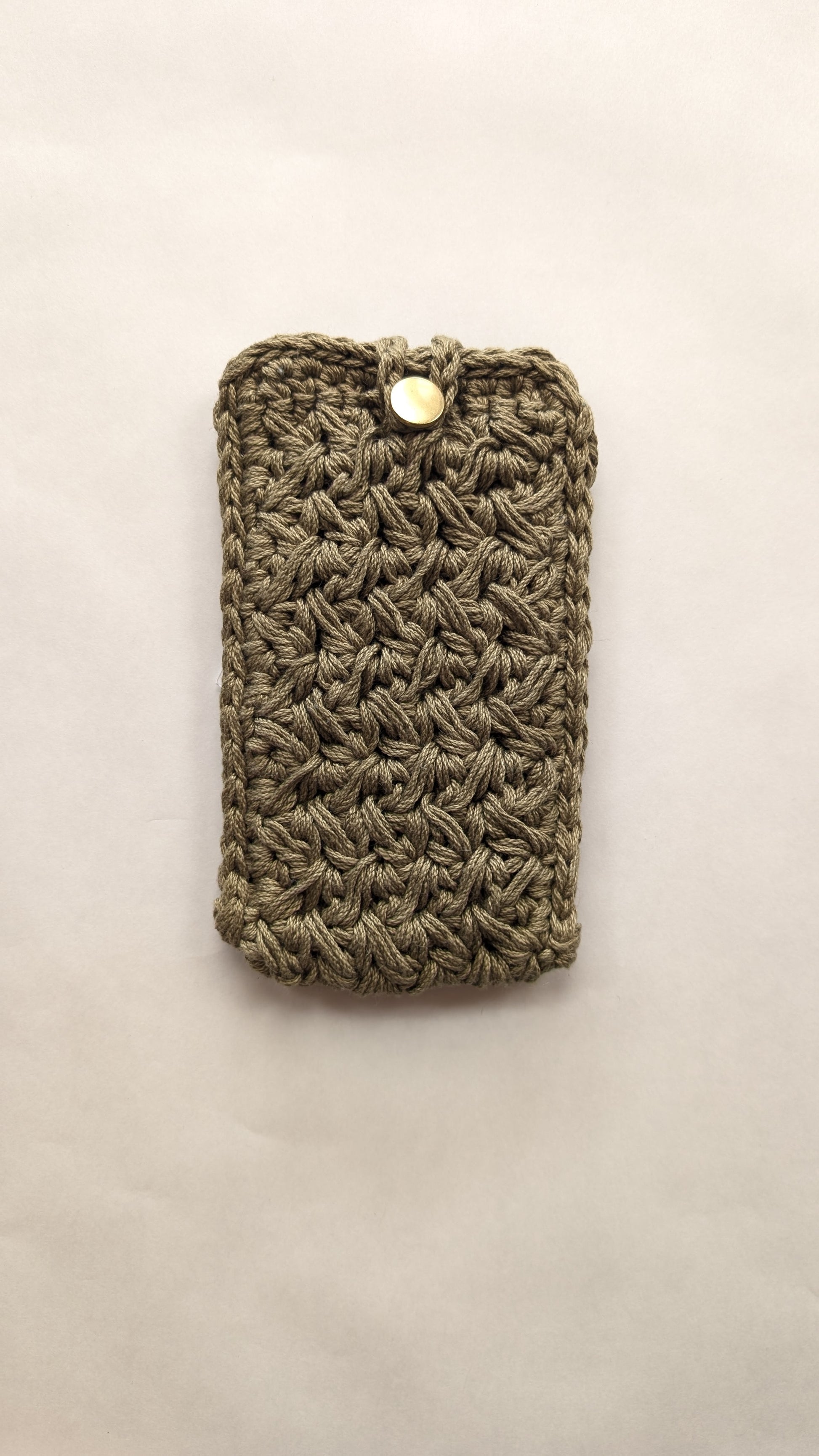 Green crocheted phone case on a light beige background
